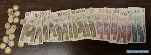 Na stole leżą rozłożone pieniądze, bilon po 5 złotych i pieniądze papierowe po 10, 20 i 50 złotych.