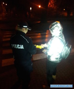 Policjantka wręcza odblaski pieszej