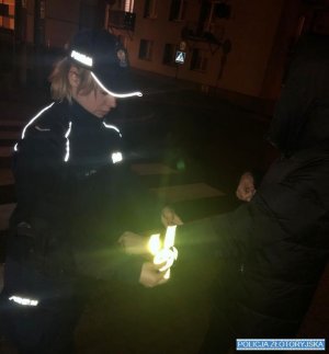Policjantka wręcza odblaski pieszej