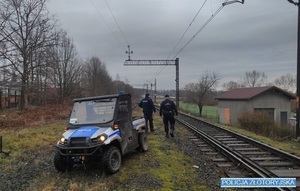 policjant i funkcjonariusz SOK idą wzdłuż torów