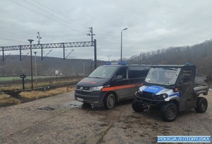 radiowóz i bus SOK obok torów kolejowych