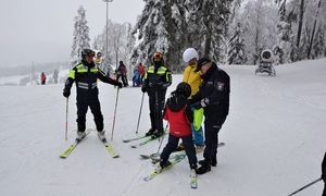 policyjny patrol narciarski i dzieci na stoku