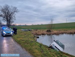 samochód w stawie, na poboczu radiowóz