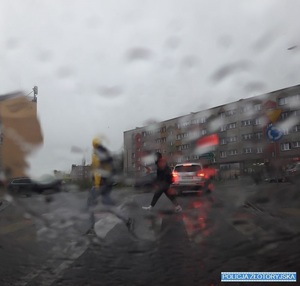 deszcz na przedniej szybie samochodu utrudniający widoczność