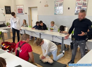 strażak i policjant uczą młodzież udzielania pierwszej pomocy