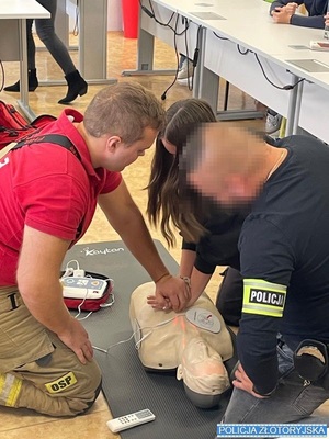 strażak i policjant uczą młodzież udzielania pierwszej pomocy