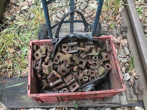plastikowa skrzynia wypełniona dużą ilością metalowych części