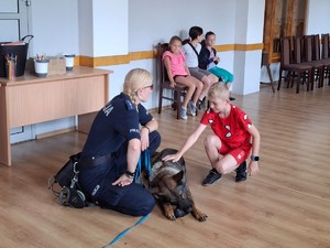 Policjantka z psem służbowym którego głaszczę  chłopiec