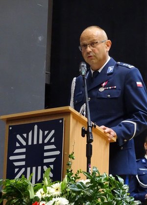 policjant w mundurze galowym, przemawia na mównicy