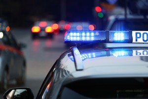 oznakowany policyjny radiowóz z włączonymi sygnałami błyskowo dźwiękowymi