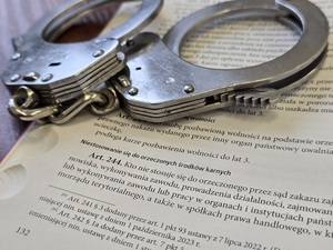 Kajdanki leżące na zbiorze przepisów prawa