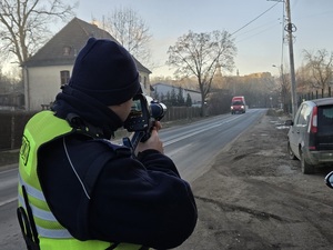 Policjant ruchu drogowego używający ręcznego miernika prędkości