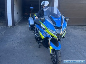 Dziecko siedzące na motocyklu policyjnym w kasku