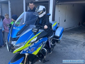 Dziecko siedzące na motocyklu policyjnym w kasku