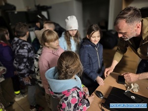 Technik kryminalistyki tłumaczący dzieciom procedury zabezpieczania śladów
