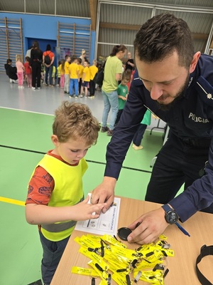Policjant wykonuje odciski palców dziecku