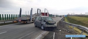 Samochód osobowy marki volkswagen na granicy pasa i pobocza autostrady a4 po zderzeniu z barierą energochłonną. Samochód ma wgniecioną całą maskę.