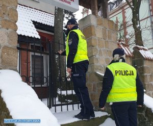 Umundurowani policjanci stoją przed wejściem do restauracji