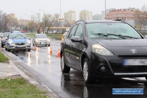 Przejście dla pieszych, przed nim samochód osobowy, za nim policyjny radiowóz