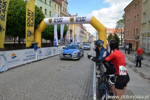 Radiowóz dojeżdżający do mety wyścigu kolarskiego