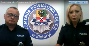 Policjant i policjantka siedzą przed ekranem komputera. w tle baner jednostki